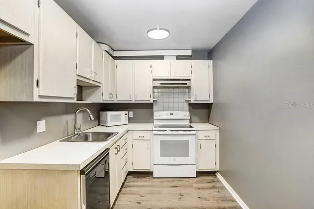 a kitchen with a stove top oven and cabinets