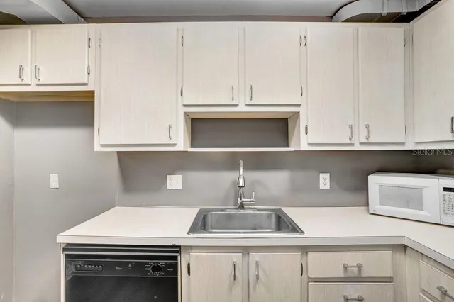 a kitchen with granite countertop white cabinets and sink