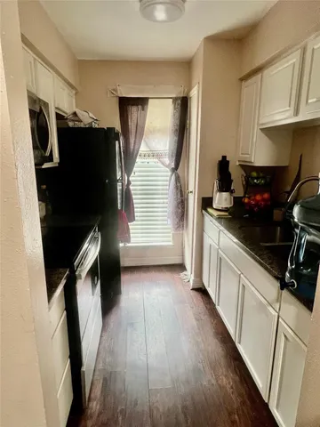 a kitchen with a sink a refrigerator and a stove top oven