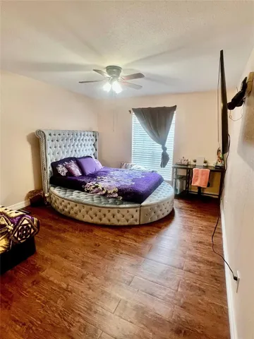 a view of a bedroom with a bed and wooden floor