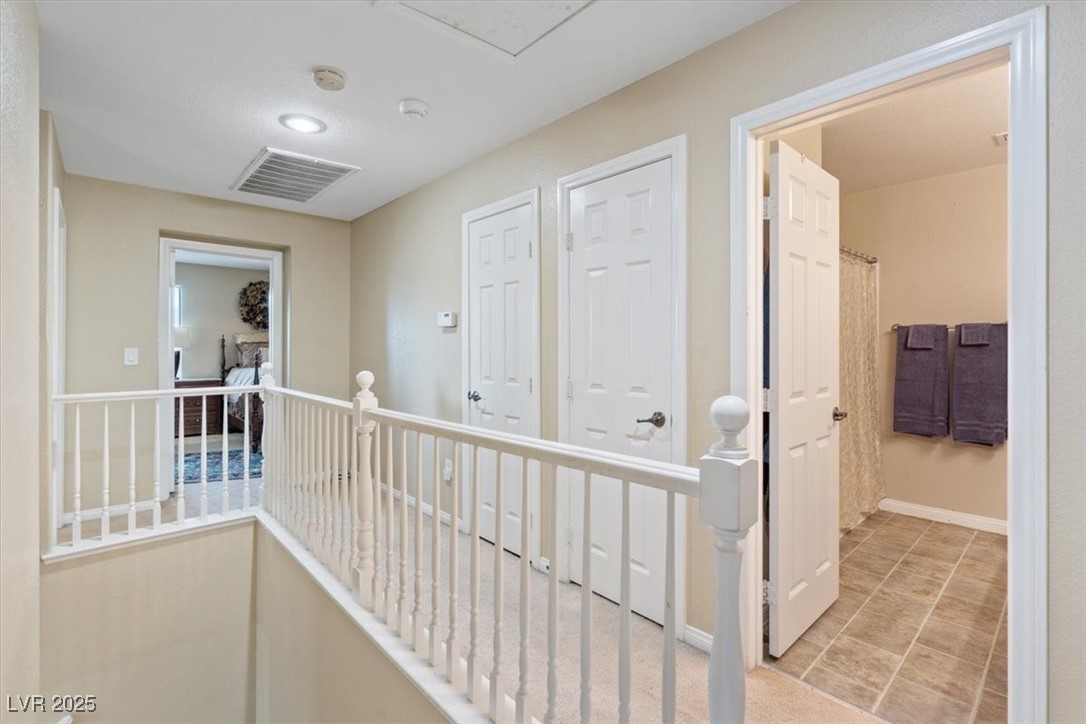 9116 Alpine Grove Avenue, Unit 103 Las Vegas, NV 89149 - Photo 13 of 30 Hall with an upstairs landing and light tile patterned flooring