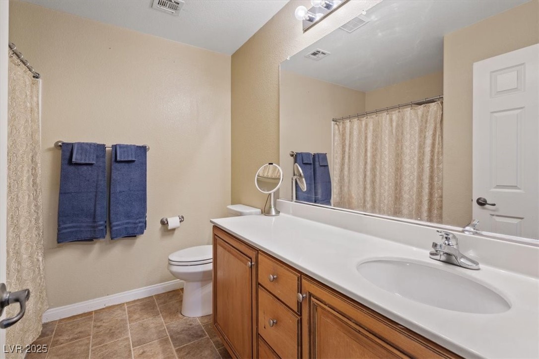 9116 Alpine Grove Avenue, Unit 103 Las Vegas, NV 89149 - Photo 16 of 30 Full bathroom featuring vanity, light tile patterned floors, and a shower with curtain