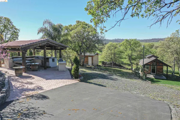 an aerial view of a house with garden space and trees in the back