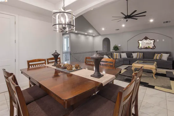 a living room with furniture a table and kitchen view