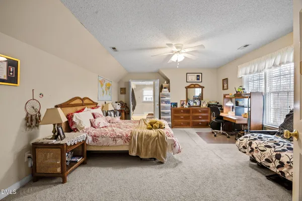 a bedroom with a bed gym equipment and a large window