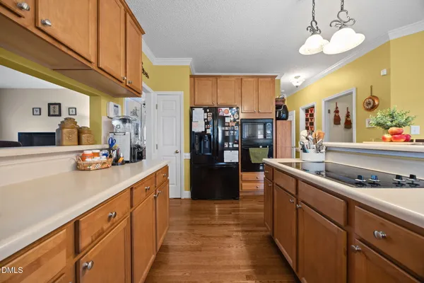 a kitchen with stainless steel appliances a sink dishwasher stove refrigerator and cabinets