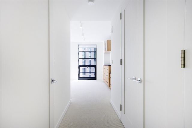 a view of a hallway with wooden floor and closet