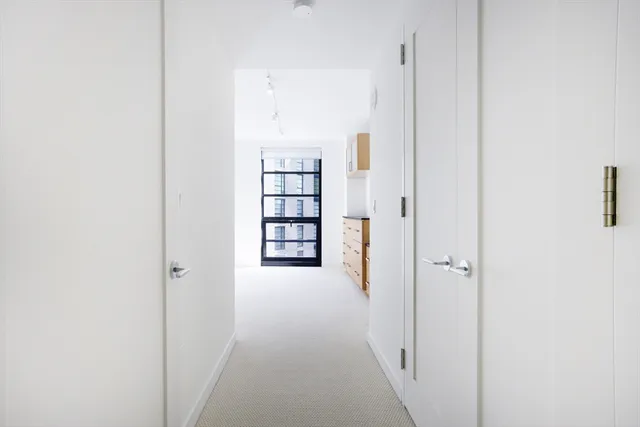 a view of a hallway with wooden floor and closet