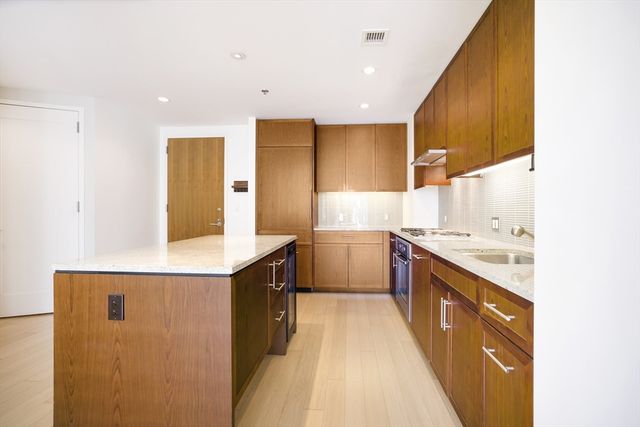 a kitchen with a sink stove and wooden cabinets