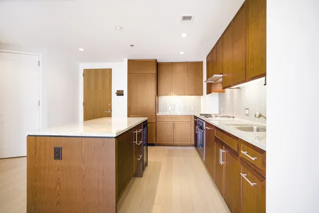 a kitchen with a sink stove and wooden cabinets