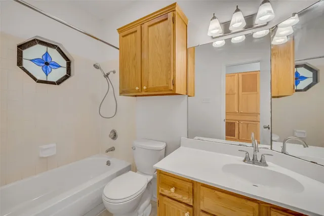 a bathroom with a granite countertop sink a toilet and bathtub