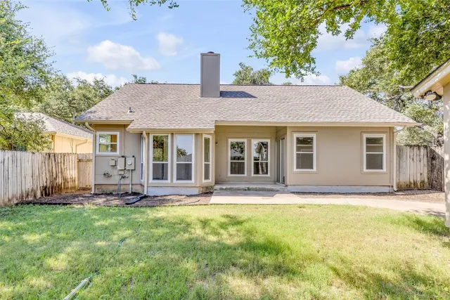 a front view of a house with a garden and trees