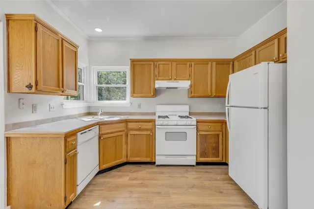 a kitchen with a refrigerator sink stove and cabinets