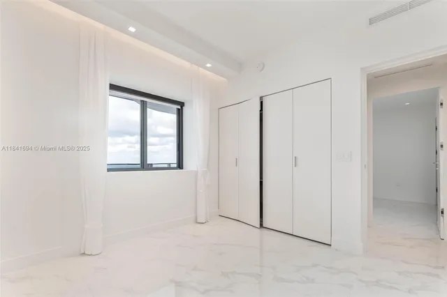 an empty room with windows and closet