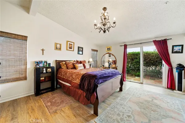 a bedroom with a large bed and a chandelier
