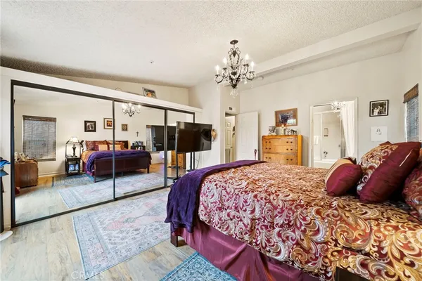 a bedroom with a large bed and a chandelier