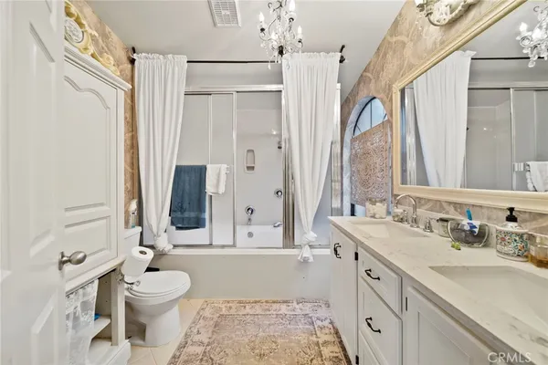 a bathroom with a double vanity sink toilet mirror and shower
