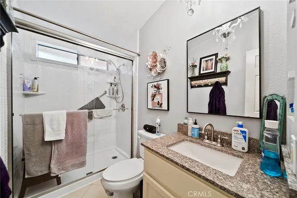 a bathroom with a granite countertop sink toilet and shower