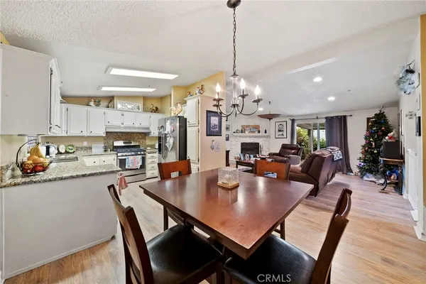 a dining room filled chandelier and wooden floor