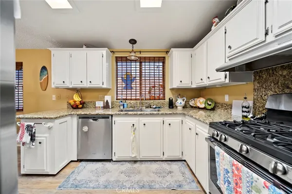 a kitchen with granite countertop cabinets stainless steel appliances and a sink