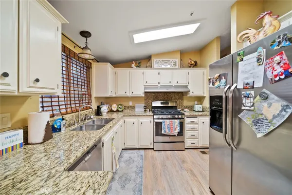 a kitchen with stainless steel appliances granite countertop a sink and cabinets