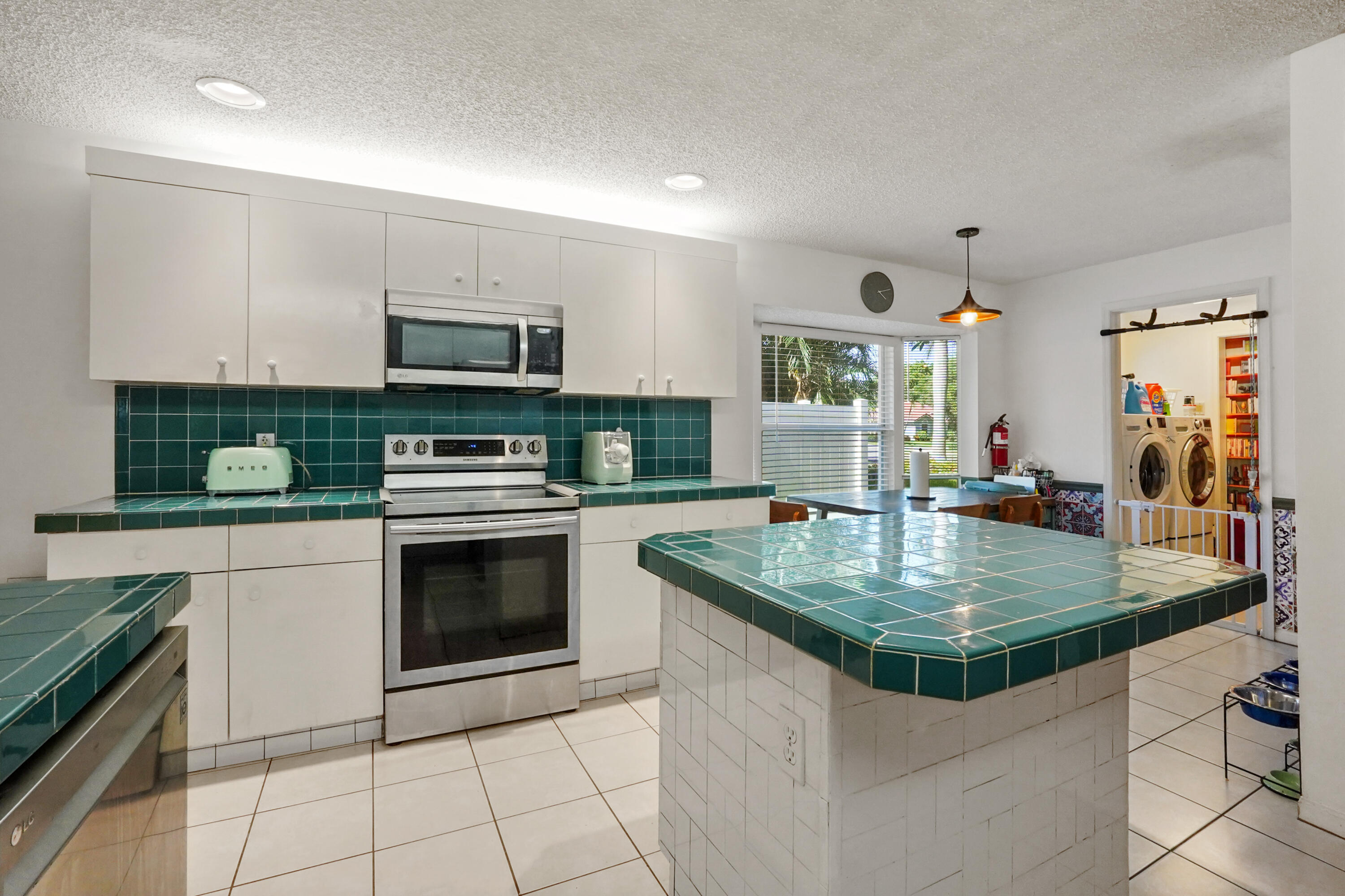 132 West Lee Road Delray Beach, FL 33445 - Photo 16 of 41 a kitchen with stainless steel appliances granite countertop a sink a stove a microwave and a refrigerator
