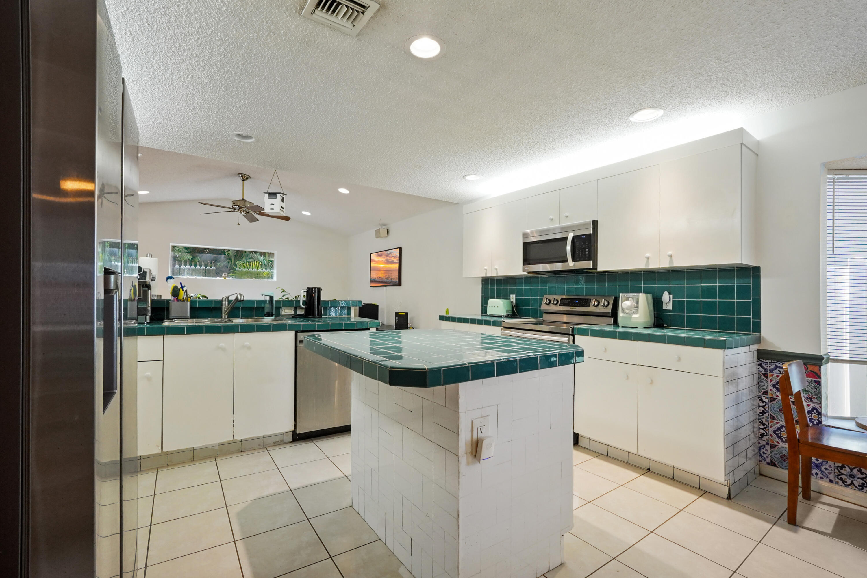 132 West Lee Road Delray Beach, FL 33445 - Photo 20 of 41 a kitchen with white cabinets and appliances