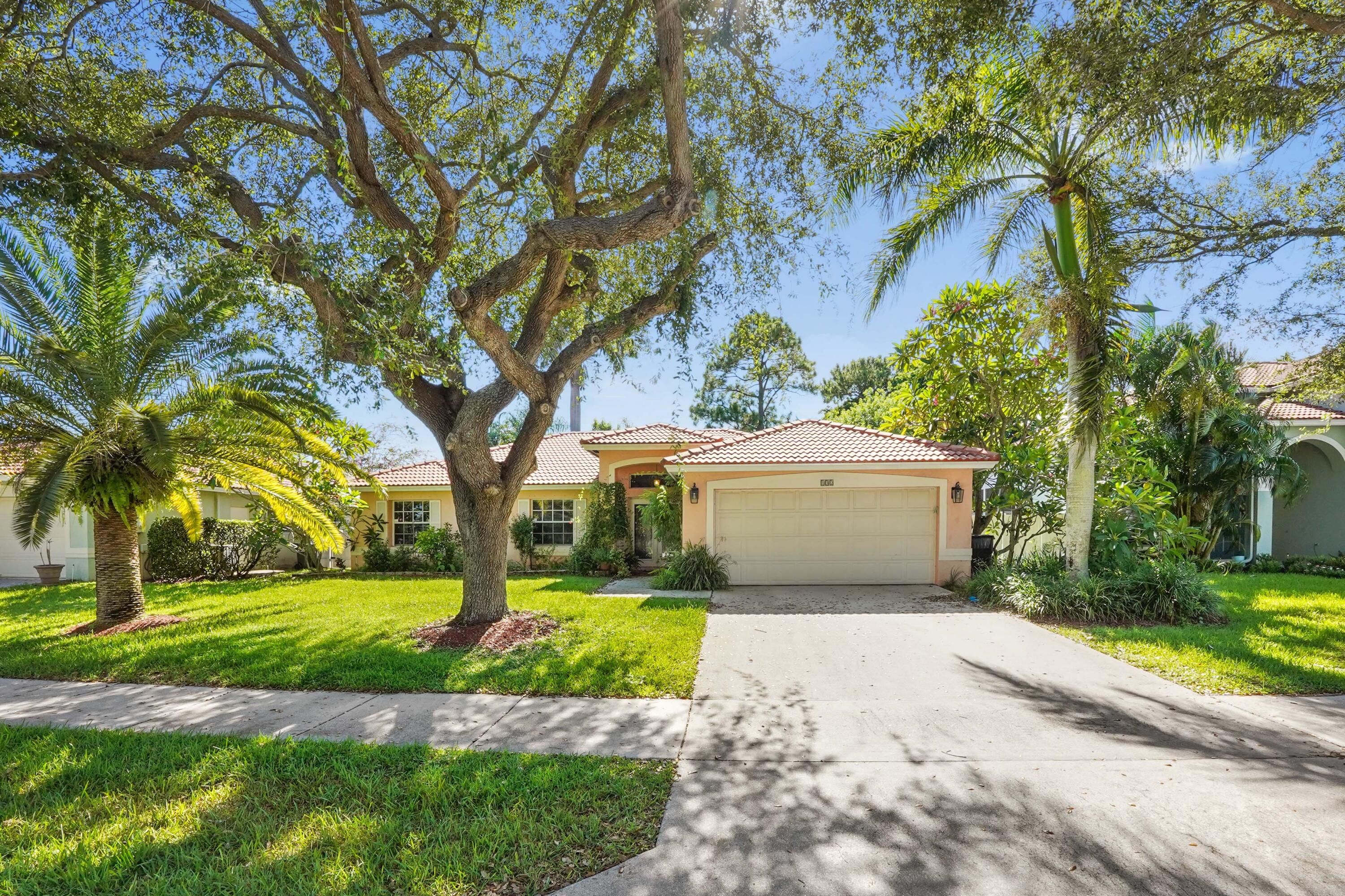132 West Lee Road Delray Beach, FL 33445 - Photo 3 of 41 a view of a white house with a big yard and large trees
