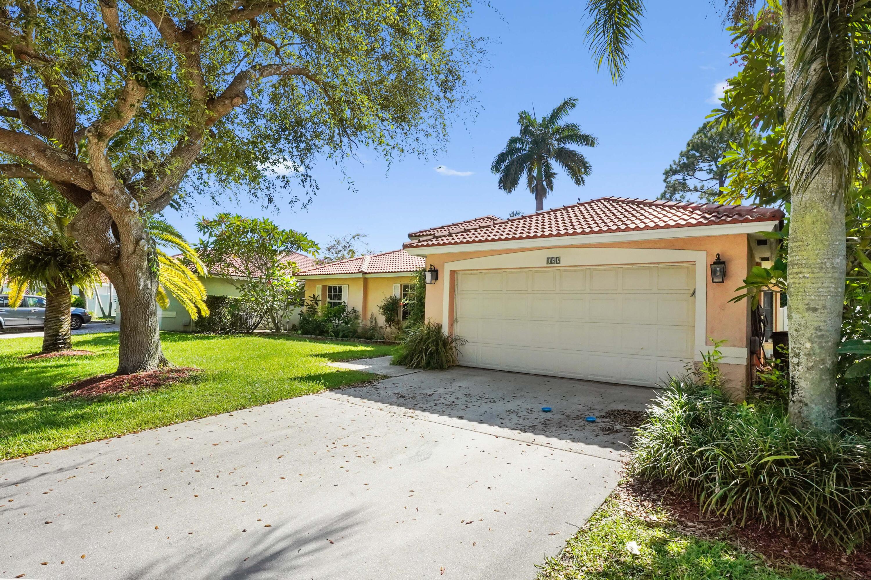 132 West Lee Road Delray Beach, FL 33445 - Photo 41 of 41 a view of a white house with a large tree and a yard