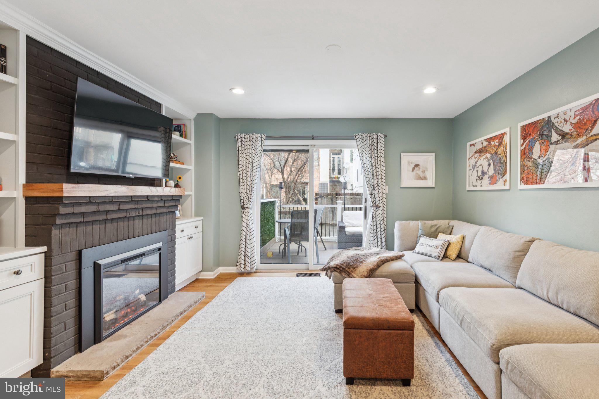 429 Gaskill Street Philadelphia, PA 19147 - Photo 32 of 63 a living room with furniture a flat screen tv and a fireplace