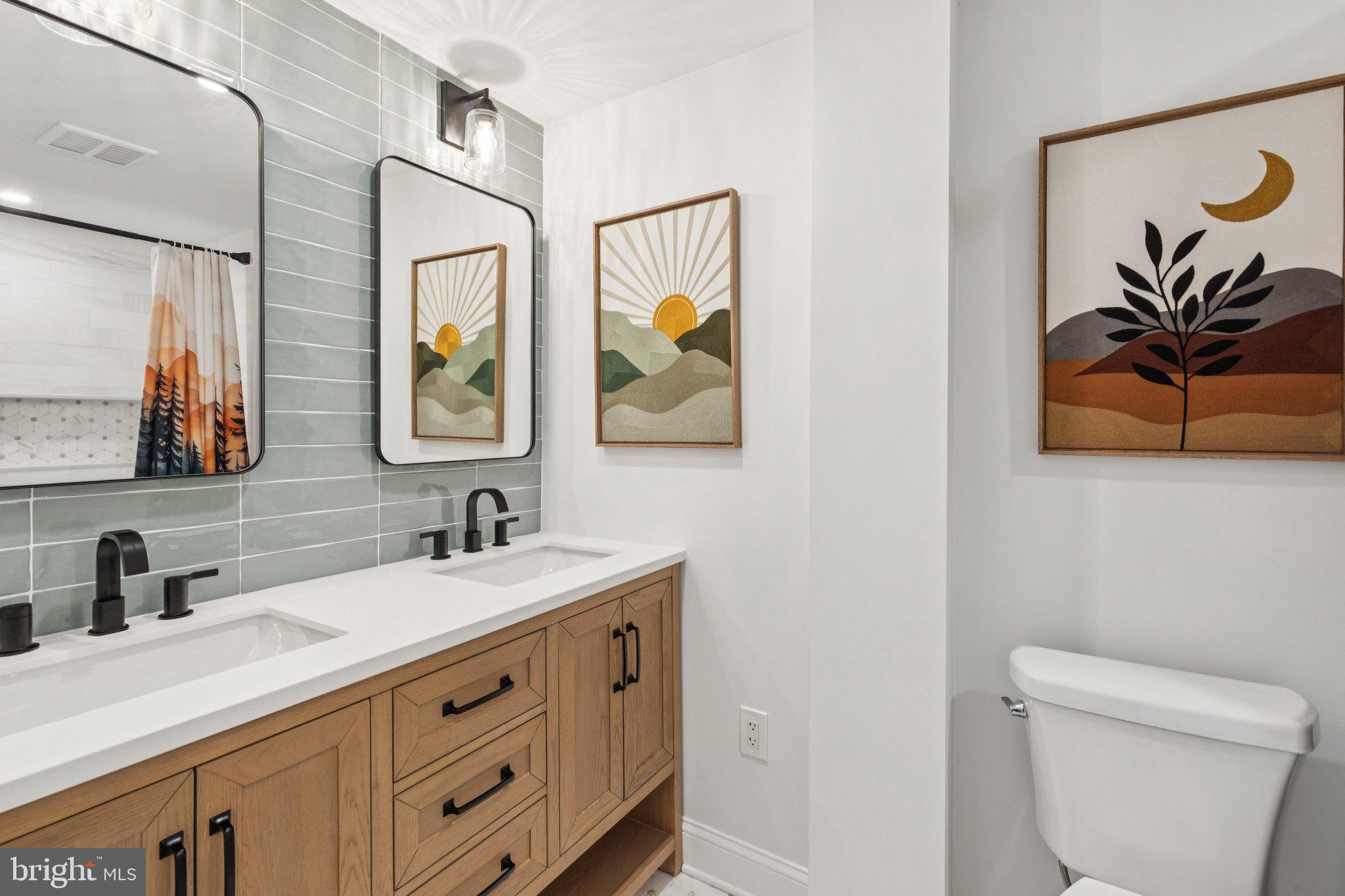 429 Gaskill Street Philadelphia, PA 19147 - Photo 43 of 63 a bathroom with a double vanity sink and a mirror