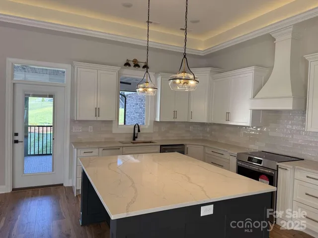 a kitchen with a stove a sink a counter space and a window