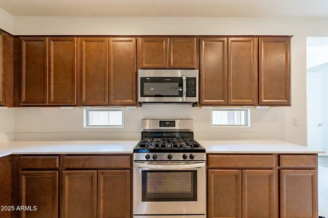 a kitchen with granite countertop a stove a microwave and cabinets