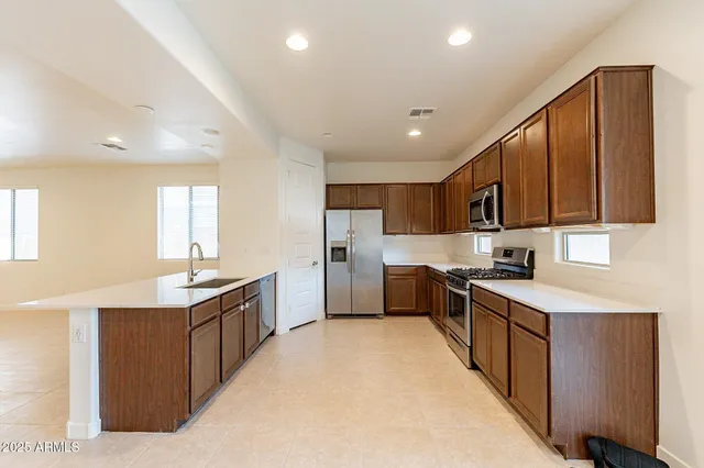 a kitchen with white cabinets sink and stainless steel appliances