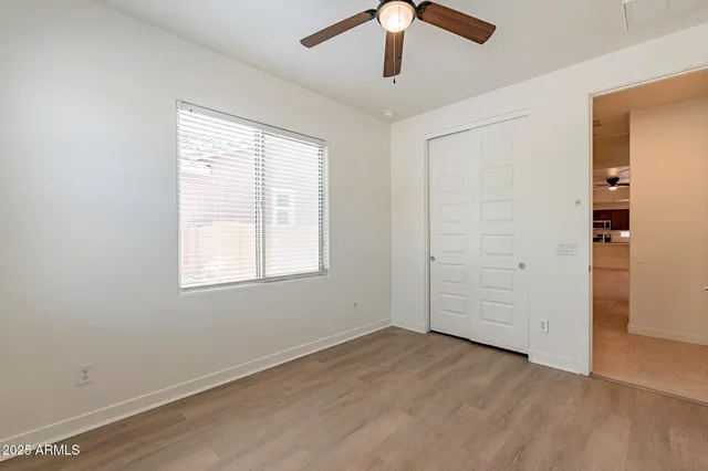 an empty room with closet and windows