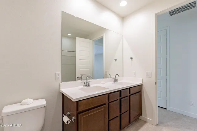 a bathroom with a sink a toilet and mirror