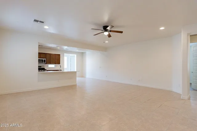 a view of empty room with wooden floor and ceiling fan