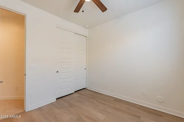 an empty room with closet and chandelier fan