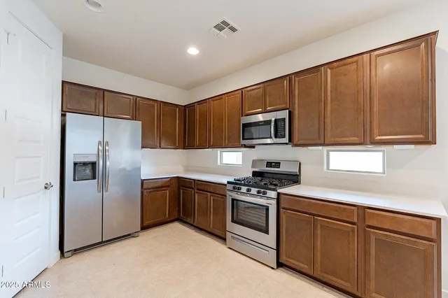 a kitchen with stainless steel appliances granite countertop a refrigerator stove and microwave