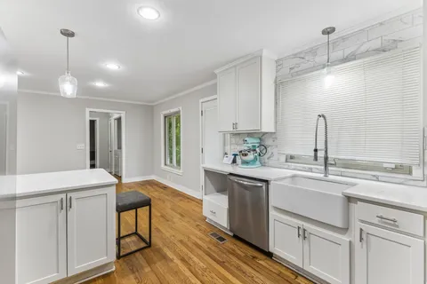 a kitchen with sink cabinets and wooden floor