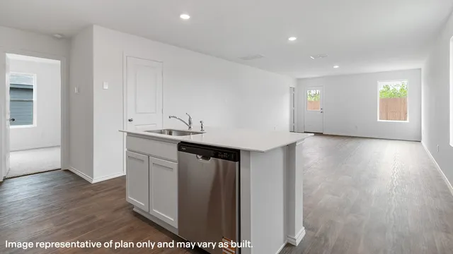 a kitchen with a sink and wooden floor