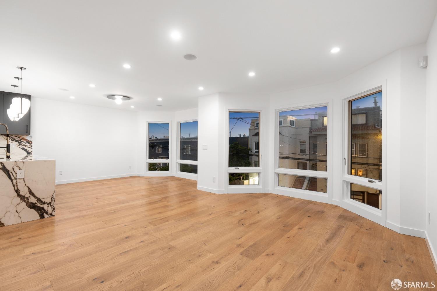 174-172 18th Avenue, Unit 172 San Francisco, CA 94121 - Photo 11 of 37 a view of an empty room with wooden floor and windows