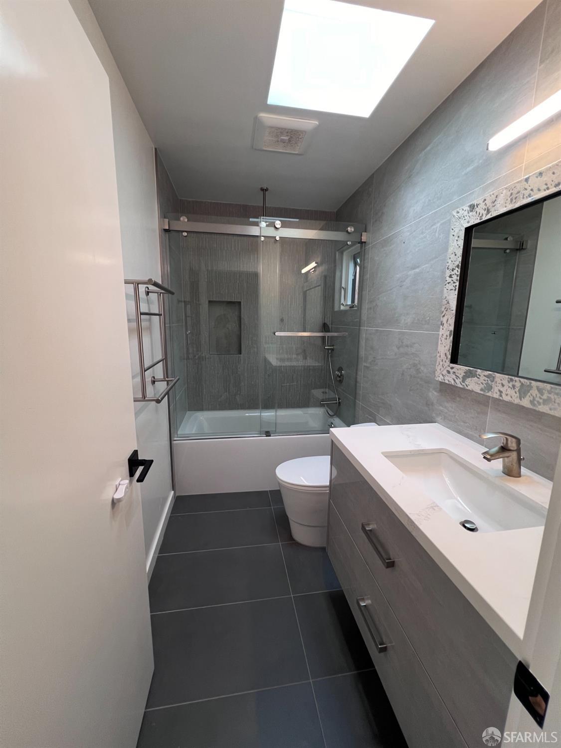 174-172 18th Avenue, Unit 172 San Francisco, CA 94121 - Photo 19 of 37 a bathroom with a double vanity sink toilet mirror and bathtub