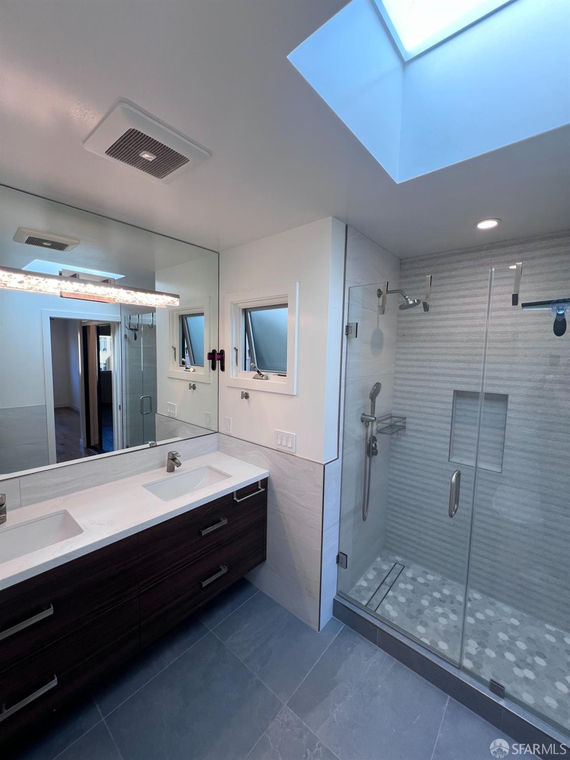 174-172 18th Avenue, Unit 172 San Francisco, CA 94121 - Photo 22 of 37 a bathroom with a double vanity sink mirror and shower