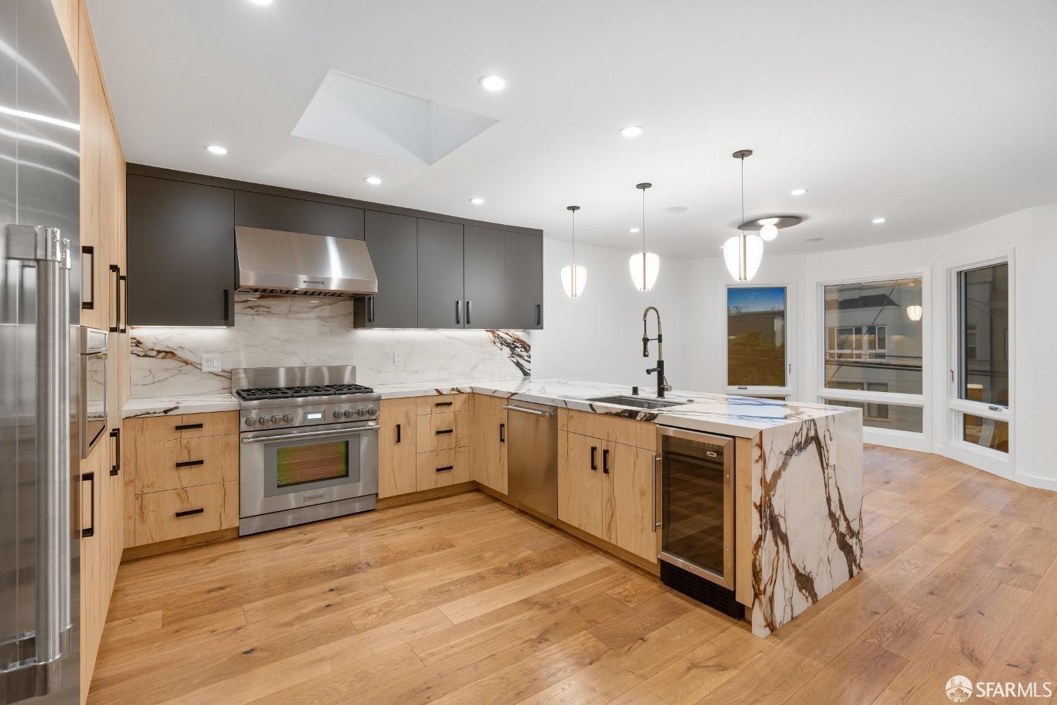 174-172 18th Avenue, Unit 172 San Francisco, CA 94121 - Photo 4 of 37 a large kitchen with kitchen island a sink and a stove top oven