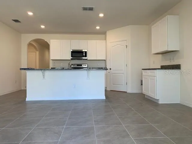 a view of kitchen with microwave and cabinets