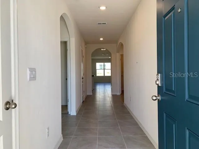 a view of a hallway with wooden floor and a bathroom