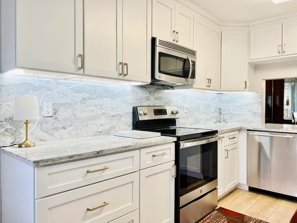 a kitchen with granite countertop cabinets stainless steel appliances and wooden floor
