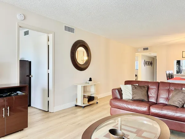 a living room with furniture a mirror and a lamp