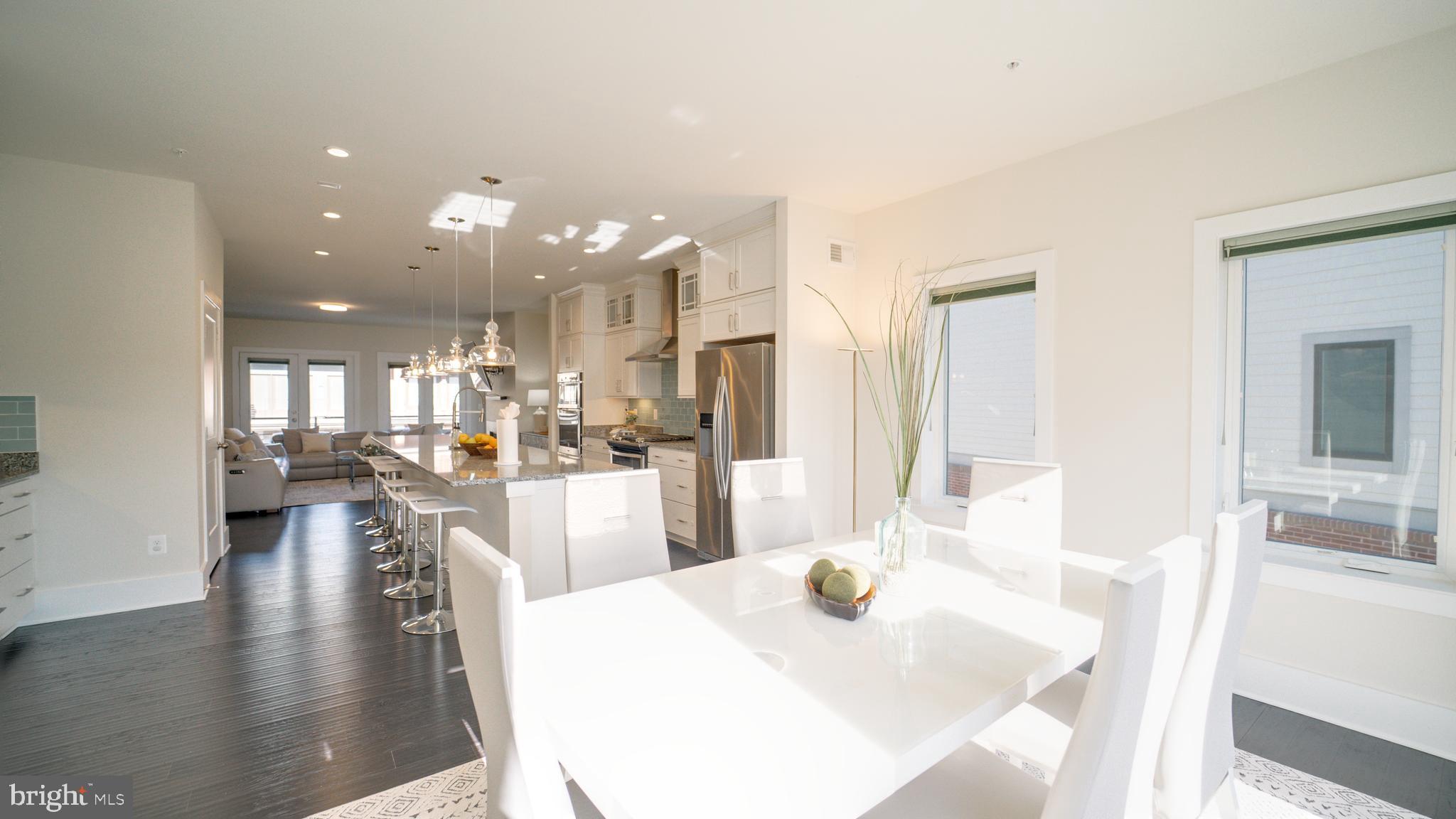 20062 Old Line Terrace Ashburn, VA 20147 - Photo 17 of 79 a view of a dining room and livingroom with furniture wooden floor a rug a fireplace and a chandelier